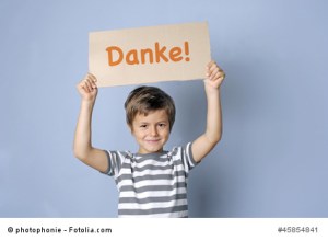 Kind sagt Danke mit einem Schild