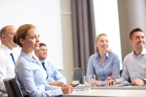 group of smiling businesspeople meeting in office